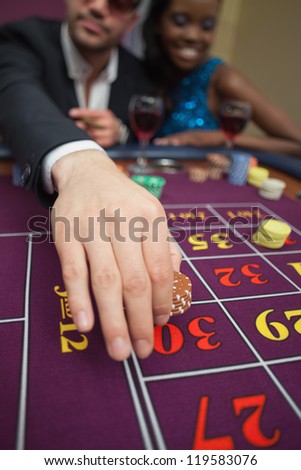 Man placing bet on roulette in casino