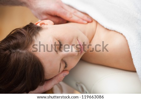 Doctor holding the head of a woman while massaging her neck in a room