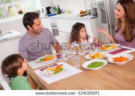 Family talking around the dinner table in kitchen