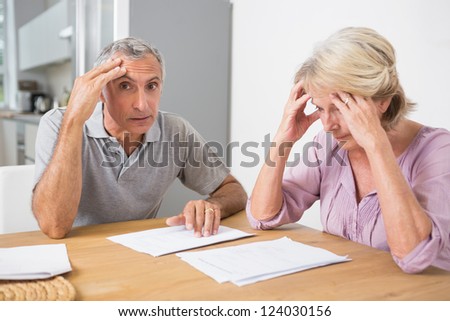 Concentrated couple reading documents together on a table