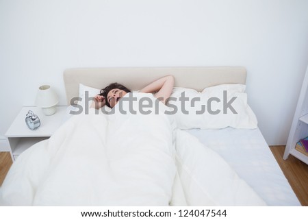 Sleepy young woman yawning in bed