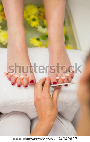 Close-up of woman polishing toe nails at spa center