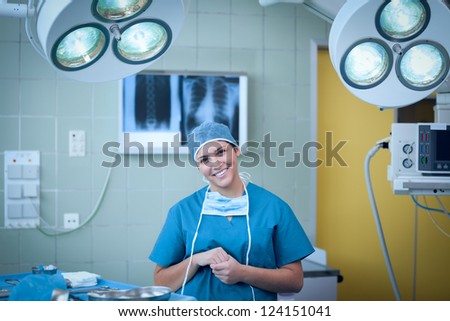 Smiling surgeon under surgical light in an operating theater