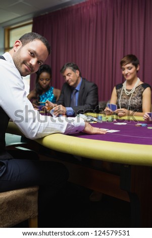 Smiling dealer at poker game in casino