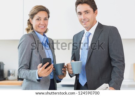 Power couple having coffee before work in kitchen