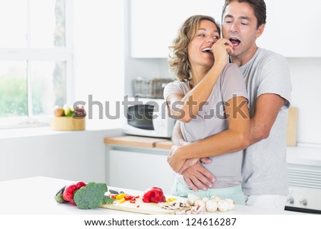 Husband and wife having fun preparing vegetables in the kitchen