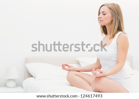 Young Woman Sitting In Lotus Position With Eyes On Bed At Home Stock ...