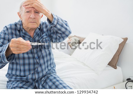 Old man with fever sitting on the bed