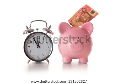 Alarm clock and piggy bank with fifty euro sticking out on white background