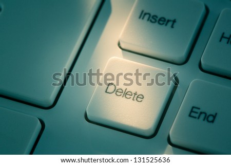keyboard with a close up of the delete key in blue