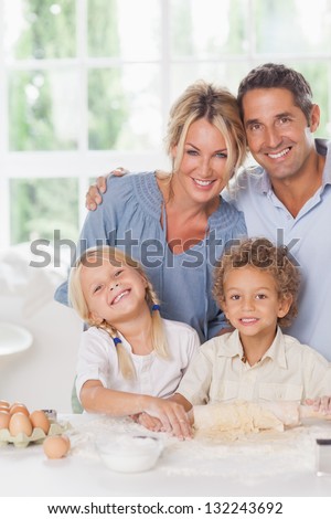 Happy mother and father baking with their children in the kitchen