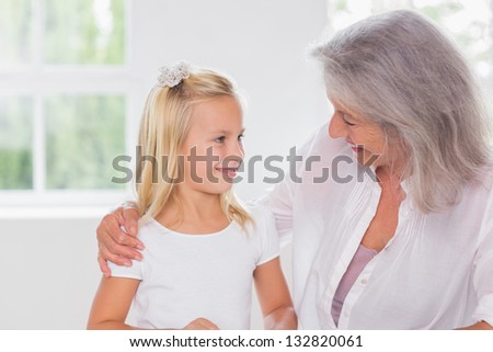 Smiling grandmother talking with her granddaughter indoors