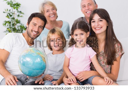 Smiling family with globe sitting on the couch