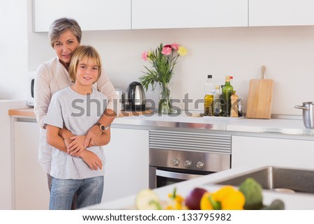 Grandmother hugging her grandson in her arms in kitchen