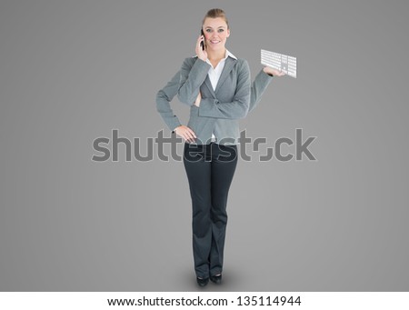 Multi-tasking businesswoman with four arms holding keyboard while on the phone