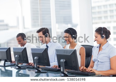 consecutive call center employees working on their computers