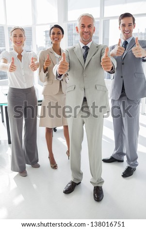 Group of business people giving thumbs up in the meeting room