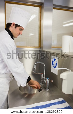 Concentrated chef washing hands in the restaurant