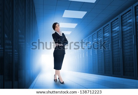 Businesswoman standing in data center and looking thoughtful