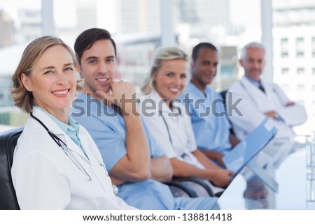 Medical team sitting in row and looking at the camera