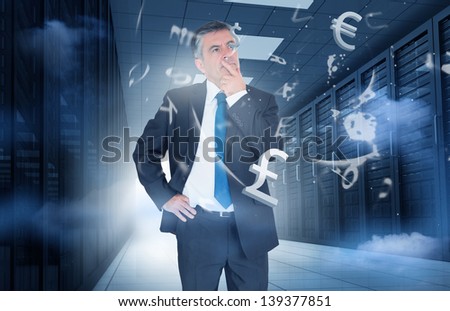 Businessman standing and thinking in data center with currency graphics