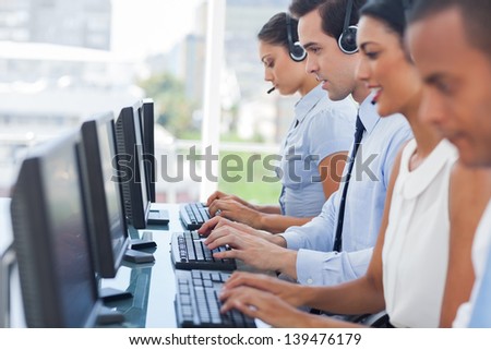 Call centre employees working on computers with their headset
