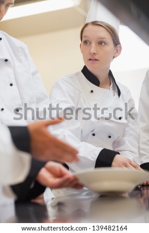 Trainee chef listening to teacher in culinary school