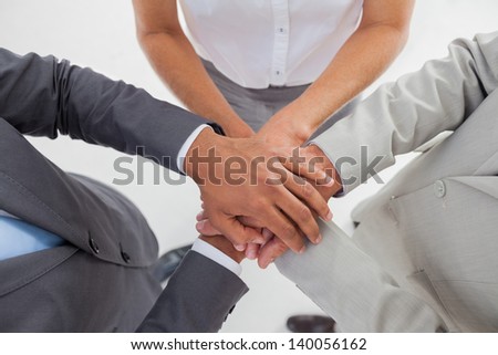 United team piling up their hands in the workplace