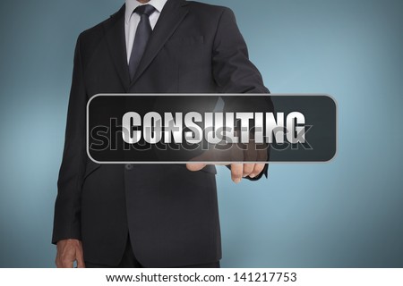 Businessman touching the word consulting written on black tag on blue background