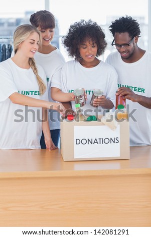Volunteers putting food in donation box in their office