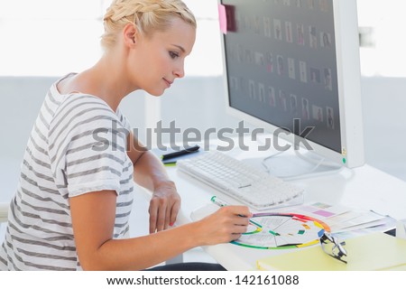 Photo editor pointing at a colour wheel in her office