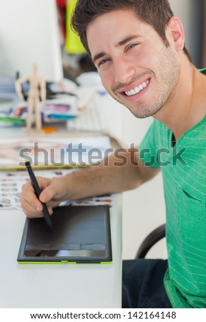 Portrait of a photo editor working on graphics tablet at his desk
