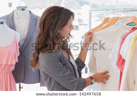 Fashion designer looking at clothes rail in her studio