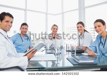 Smiling medical team during a meeting looking to the camera