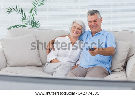 Mature couple watching television sitting on the couch