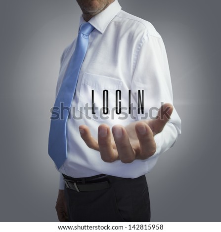 Businessman holding the word login on grey background