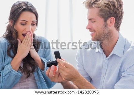 Man asking partner to marry him by giving her a engagement ring