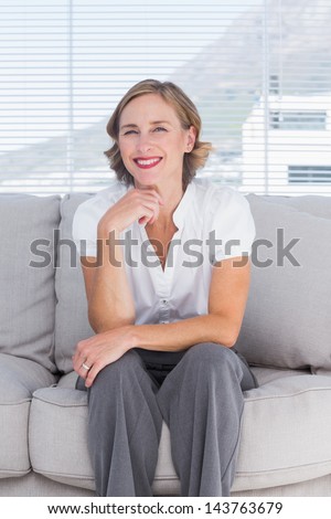 Confident businesswoman sitting on couch in the bright office