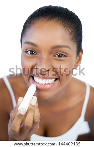 Woman putting lip balm on her lips on white background