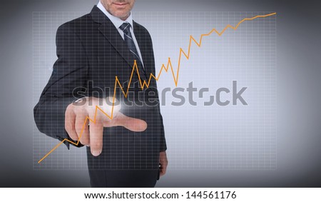 Businessman touching an orange curve on grey background