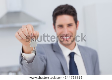 Real estate agent presenting house key in a kitchen