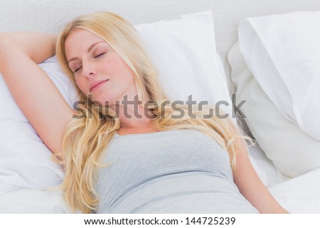 Blonde woman sleeping in her bed
