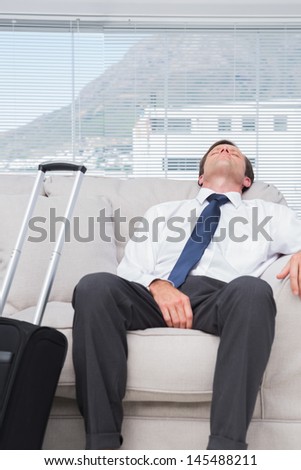 Exhausted businessman sleeping on couch