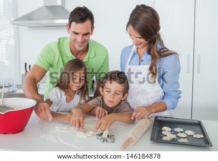 Siblings home baking together in the kitchen with parents