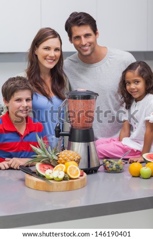 Smiling family using a blender together in the kitchen