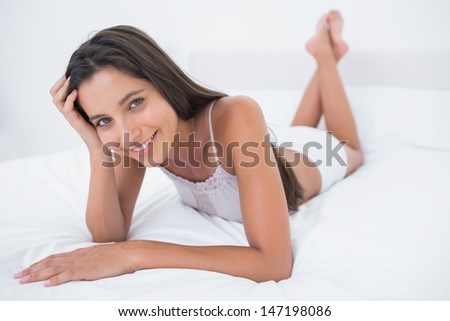 Portrait of a pretty woman relaxing lying in bed in the bedroom