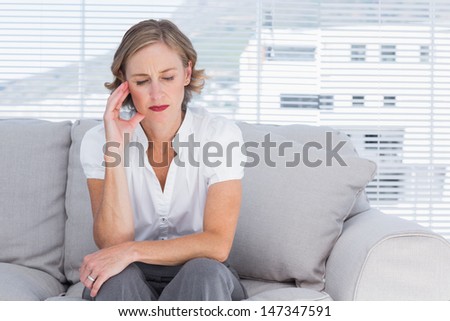 Worried businesswoman sitting on couch