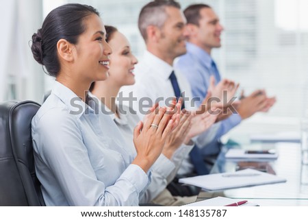 Cheerful employees in bright office applauding for presentation