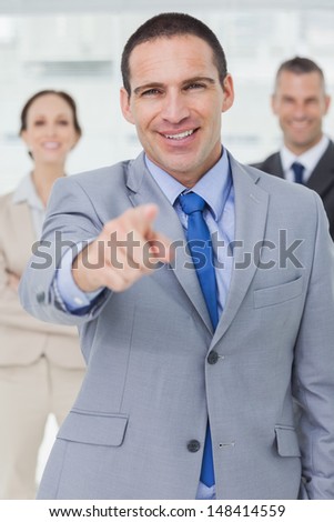 Entrepreneur posing pointing out at camera in bright office