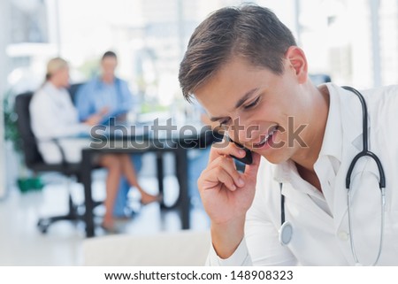 Young doctor having a phone call in medical office